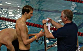 Boulder City High senior Zane Grothe is presented a medal for placing third on Saturday in the 500 freestyle at the Southern California Swimming Grand Prix in Long Beach, Calif. Swimming legend Michael Phelps won the race. Phelps' coach, Bob Bowman from North Baltimore Aquatics Club., is giving Phelps his medal. 
 
