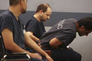 Bandaged after a failed suicide attempt, Gregory Hover, center, waits to be called by Las Vegas Justice of the Peace Joseph Sciscento during an arraignment hearing Friday, Feb. 12, 2010, at the Regional Justice Center.   Hover is facing multiple felony counts including murder, kidnapping and robbery in connection with the Jan. 25 violent home invasion of Julio and Roberta Romero.