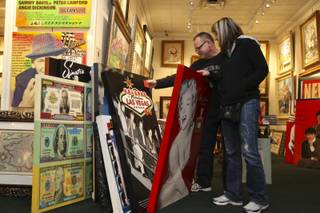 Bill and Sarah Turner, of Ohio, peruse the paintings of the late artist Steve Kaufman on display Sunday, Feb. 14, at the Centaur Art Gallery in the Fashion Show Mall. Kaufman, 49, of Sherman Oaks, Calif., was found dead Feb. 12 in Vail, Colo.