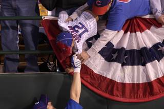 Jason Reimer holds his 4-year-old son, Ethan, while Mike Fontenot of the Chicago Cubs signs his jersey Friday at Cashman Field before the Cubs and Chicago White Sox played their first of two exhibition games.