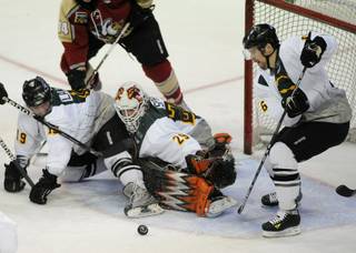 Wranglers winger Mick Lawrence stretches out to help deflect a puck away from goaltender Jimmy Spratt as defenseman Matt Deschamps (6) prepares to clear it from danger during the first period as Las Vegas hosted Bakersfield at the Orleans Arena on Friday night.
