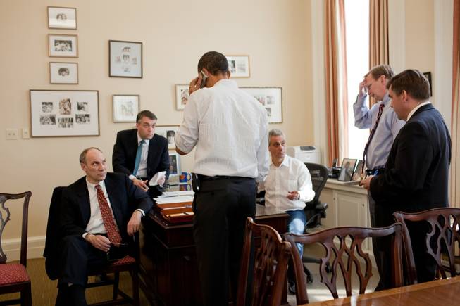 This photo provided by the White House taken Sunday, March 21, 2010, shows President Barack Obama talking on the phone with a member of Congress in the Chief of Staff's office at the White House. Aides, from left are, Phil Schiliro, Sean Sweeney, Rahm Emanuel, Jim Messina, and Dan Turton.
