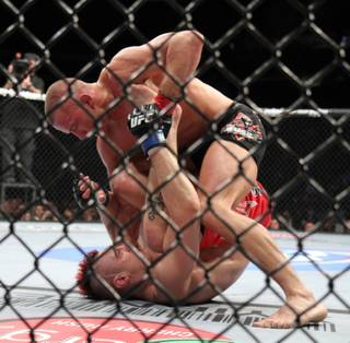 UFC welterweight champion Georges St. Pierre, top, in action against Dan Hardy during their match at the Prudential Center in Newark, N.J., on Saturday, March 27, 2010.  St. Pierre methodically defeated Hardy by a unanimous, five-round decision in the main event of UFC 111 and retained his welterweight belt.