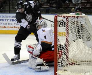 Ryan Weston slips the puck through the five hole of Utah goalie Mike Morrison for a first period goal on Sunday afternoon at the E-Center in West Valley City.