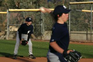 After reaching his maximum pitch count earlier in the week, pitcher Justin Rasavage playes first while Griffin Haddrill pitches during a Peccole Little League game Wednesday, April 21, 2010.