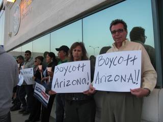 Gloria Flores, 48, and Rick Erlich, 60, attend an immigration reform vigil Wednesday night in protest of Arizona's new immigration law.