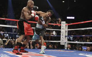 Floyd Mayweather Jr. (L) takes a punch from Shane Mosley during their welterweight fight Saturday at the MGM Grand Garden Arena.