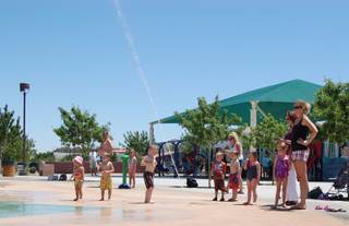 Parents and children enjoy the splash pad at Paseo Vista Park in Henderson Sunday afternoon. The park is one of eight in Henderson with the splash pad feature. 
