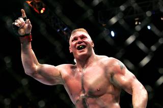 Brock Lesnar points to the stands after submitting Shane Carwin in the second round of their heavyweight title fight Saturday at UFC 116. Lesnar won with a second-round submission.