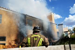 Firefighters battle an afternoon fire Thursday at 2546 Valencia Circle, near Wigwam Parkway in Henderson.