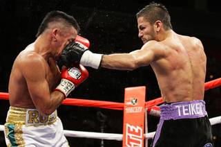 Rocky Juarez, left, of Houston, Texas, takes a punch from Jorge Linares of Venezuela during the WBA Fedelatin lightweight title fight Saturday at the Mandalay Bay Events Center.