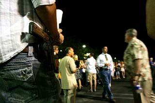 Miles Plannette carries his gun Tuesday during a candlelight vigil for Erik Scott, who was killed outside a Summerlin Costco by Metro Police last month.