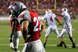 UNLV defensive back Alex De Giacomo walks back to the line of scrimmage as Wisconsin quarterback Scott Tolzien congratulatse wide receiver Jared Abbrederis after a Wisconsin touchdown in the second half of their season opening game Saturday, September 4, 2010 at Sam Boyd Stadium. Wisconsin won the game 41-21.