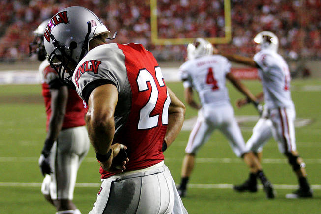 UNLV defensive back Alex De Giacomo walks back to the line of scrimmage as Wisconsin quarterback Scott Tolzien congratulatse wide receiver Jared Abbrederis after a Wisconsin touchdown in the second half of their season opening game Saturday, September 4, 2010 at Sam Boyd Stadium. Wisconsin won the game 41-21.