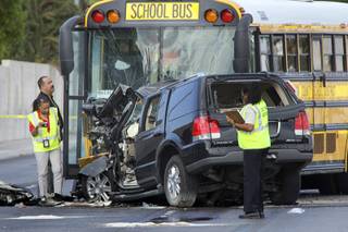 Officials investigate a fatal accident on Decatur Boulevard near Lone Mountain Road Wednesday, October 6, 2010. The driver and a passenger in the sport utility vehicle died, police said. No children were on the bus.