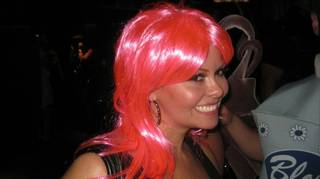 A very pink wig, about which she is clearly pleased.