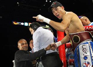 WBO featherweight champion Juan Manuel Lopez of Puerto Rico speaks with fans as he leaves the ring after defeating Rafael Marquez of Mexico on Saturday at the MGM Grand Garden Arena. Former boxing champion Felix Trinidad of Puerto Rico is at lower left.