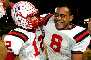 Liberty quarterback Kai Nacua (L) and running back Teu Tai celebrate during the closing minutes of their game against Las Vegas Friday, November 19, 21010. Liberty won 35-14.