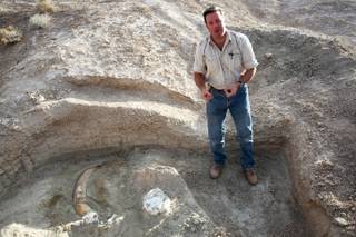 Eric Scott, a paleontologist from the San Bernardino County Museum, talks Thursday about a partially unearthed Columbian Mammoth tusk in the proposed Tule Springs National Monument area located in the northern part of the Las Vegas Valley.