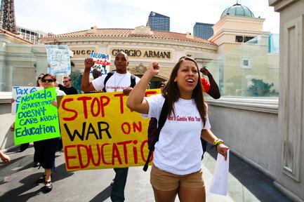 UNLV students Chuck Ticer, 21, and Brionna Simons, 20, protest against education budget cuts while making their way across a pedestrian bridge over Las Vegas Boulevard on Sunday, March 6, 2011, in Las Vegas.