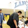 Photo: Volunteer Cheryl Lockhart, from right, helps voter
