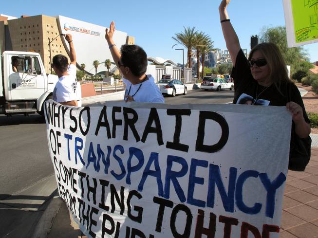 Alma Chavez, right, cheers as passing motorists on Grand Central Parkway honk in support of seeking justice for her son, 23-year-old Ralfy Olivas, who was fatally shot by Metro Police July 14. The group gathered outside the Clark County Governance Center Tuesday morning to support changes to the coroner's inquest system.