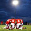 Photo: Members of Liberty kneel together before taking on Photo: Members of Liberty kneel together before taking on