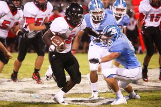 Las Vegas running back Farrell Victor stiff arms Centennial defensive player  during their game Friday, September 2, 2011 at Centennial High School. .  Las Vegas came from behind for a 24-21 win.