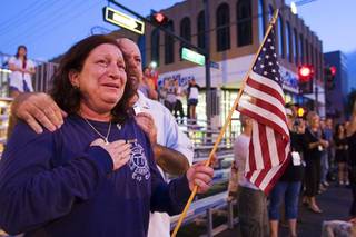 John and Lisa Karounos, originally of New York, watch as fire trucks pass by during a Heroes Parade in downtown Las Vegas Sunday, Sept. 11, 2011. Michael Ragussa, a relative, was a firefighter killed in the 9/11 terrorist attacks, John Karounos said. The parade began at 5:46 a.m., the moment the first tower was hit on 9/11.   