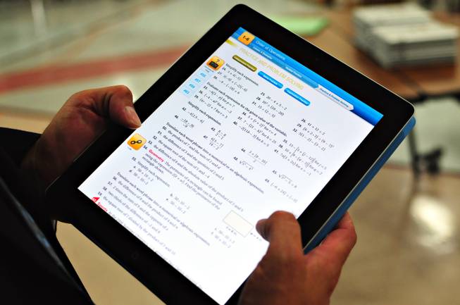 Houghton Mifflin Harcourt Senior Vice President of Corporate Affairs Josef Blumenfeld holds an iPad 2 loaded with the "Fuse" Algebra 1 interactive textbook at Silverado High School on Tuesday, Sept. 13, 2011. The Clark County School District launched a pilot program using an iPad application to teach algebra to students at four schools during the 2011-12 school year. There will be 1,150 students using the algebra application on the iPad, developed by Houghton Mifflin Harcourt. The iPads with software cost the School District $790,050.