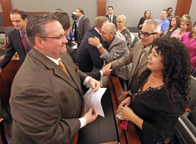 Plaintiff Anne Arnold (right) reacts along with attorney's Robert Adams (left) and Robert Eglet (center) hugging Anthony Devito after a jury Monday, Oct. 10, 2011, ordered three pharmaceutical companies to pay $162.5 million in punitive damages to five plaintiffs in a lawsuit that accused them of negligently distributing large vials of an anesthetic to Las Vegas clinics at the center of a 2008 hepatitis C outbreak.