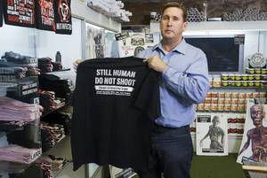 Mike Monko, president of Zombie Apocalypse Inc., displays a T-shirt in the Zombie Apocalypse Store, 3420 Spring Mountain Rd., Tuesday, Jan. 24, 2012. The store, which opened last November, sells survival gear, ammunition and Zombie-themed products.
