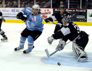 Matt Ambroz (20) pursues the puck after it is swept to the side by Las Vegas goaltender Joe Fallon during the first period on Thursday night, Fallon's 100th career professional start.