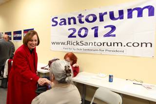 Sharron Angle shake hands with a Rick Santorum supporter at Santorum's campaign headquarters in Las Vegas Friday night. Angle endorsed Santorum on Wednesday.