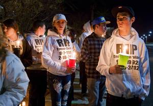 Jen Marquardt, left, and Richie Peterson wear sweatshirts in honor of Trevor Zarvian, 19, during a vigil at Windmill Parkway and Thayer Avenue in Henderson Sunday, Feb.19, 2012. Zarvian died in an auto accident at the site Saturday. Also killed was Johnny Castiblanco, 19, and an 86-year-old man.