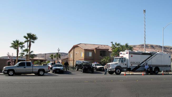 Metro Police surrounded the Southwest Ranch Condominiums, 9925 Russell Road, Thursday morning as they searched for a suspect who they said rammed his truck into a nearby home's garage. Police received reports of shots fired, but they have not determined whether a shooting actually occurred.