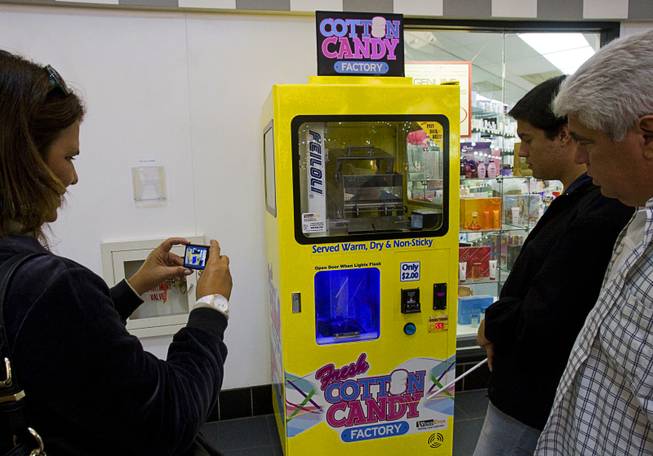 A shopper takes a video on her camera as fresh cotton candy is made in a vending machine in the Las Vegas Premium Outlets mall on Las Vegas Boulevard South Wednesday, March 7, 2012. The "Vendever" is a cotton candy vending machine that dispenses the sweet treat in countries all over the world, caters to people who want cotton candy on the go. Construction on the machine was finished in Henderson and the fresh cotton candy can be found at the Las Vegas Premium Outlet malls, in Regal Theaters in select Station Casinos and now local Chuck E. Cheese's. Vaughn Williamson, who partnered with Vendever to create the machine, said the two dollar batch of cotton candy is made right in front of customers through a clear glass, creating a spinning affect with robotic movements. The machines are refilled weekly and dish out 125 to 250 servings of cotton candy a week, said Williamson.
