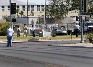 Officials investigate a single-vehicle fatal crash at Lake Mead Boulevard at Tonopah Drive Monday, April 2, 2012. The car crashed into a utility box, killing the driver and sending the passenger to the hospital, police said.