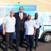 Penn Jillette with Opportunity Village drivers in front of the two vehicles purchased using a portion of the $250,000 donated by Caesars Foundation to Opportunity Village.