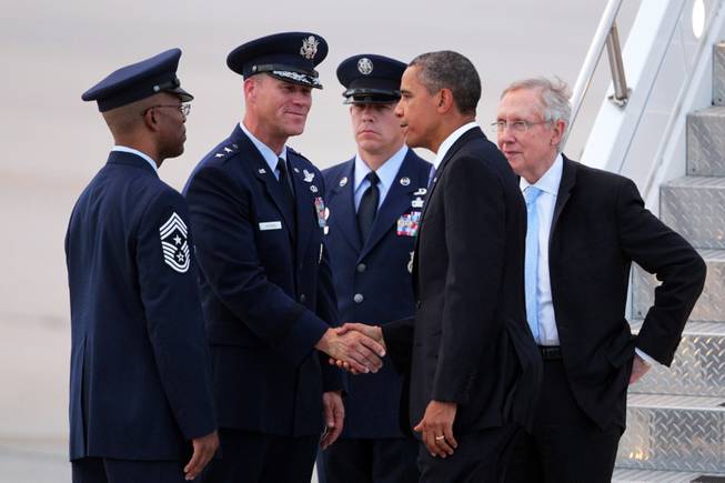 President Barack Obama, Sen. Harry Reid, D-Nev., greets Chief Master Sgt. Robert Ellis, Commander Chief of the U.S. Air Force Warfare Center at Nellis, from left, and General Jeffrey Lofgren, Commander at the U.S. Air Force Warfare Center at Nellis, after arriving at Nellis Air Force Base northeast of Las Vegas on Tuesday, August 21, 2012.