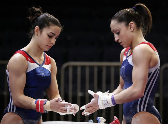 Alexandra Raisman, left, and Jordyn Wieber apply chalk to their hands before practicing on the uneven bars during a training session for Saturday's American Cup gymnastics meet at Madison Square Garden in New York, Friday, March 2, 2012. Wieber, the reigning world champion, is the favorite to win the event again this year.