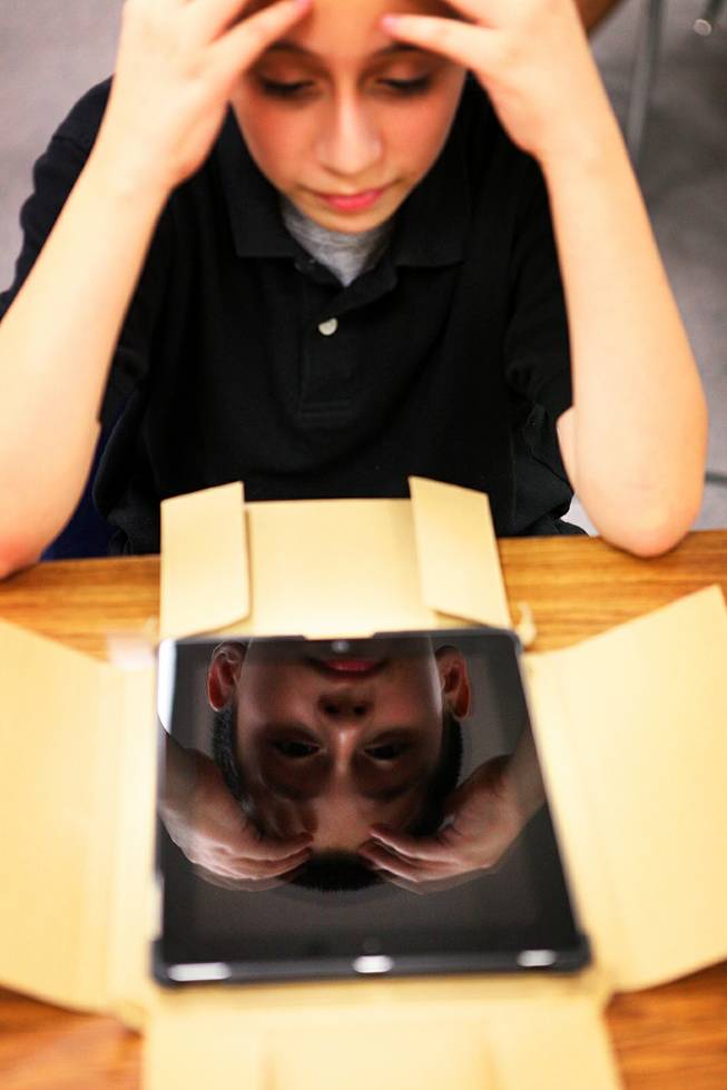 Sixth grader Mario Garfias' face is reflected in his new iPad on Thursday, September 19, 2012 at Ed Von Tobel Middle School in Las Vegas. The Clark County School District's "e3: Engage, Empower, Explore Project" provided iPads for all students and teachers at five Title I middle schools.