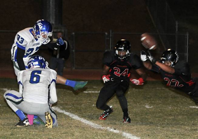 Wildcat offensive linebacker Jacob Littlefield (22) nearly deflects an extra point attempt by Green Valley kicker Conor Perkins as the two teams met at Las Vegas High School on Friday night. Also pictured, Wildcat corner Critian Slack (24), and Gator receiver Kohorst Quintin (6) serving as place holder.