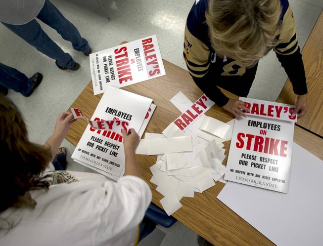 Union members Ronda Zanelli, left, and Elissa Hardy, right, construct picket signs Monday, Oct. 29, 2012, at the Sacramento Central Labor Council in the Natomas community of Sacramento, Calif., as staffers, union members and retirees gathered in preparation for a possible strike against Raley's supermarkets.