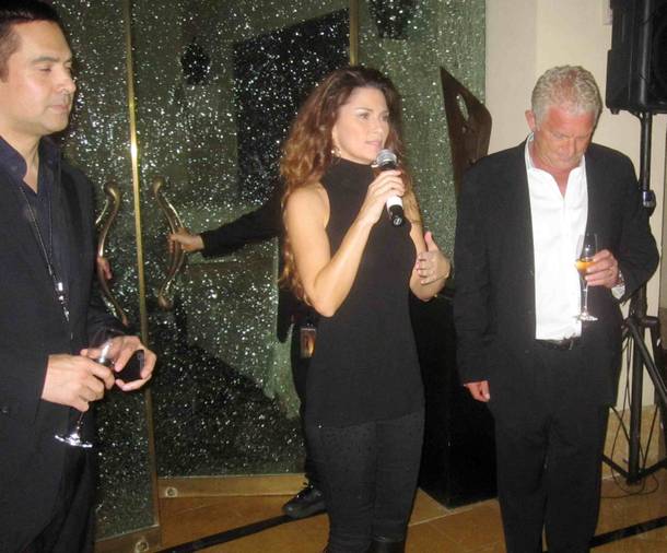 Shania Twain is flanked by Raj Kapoor and John Meglen as she makes remarks at her