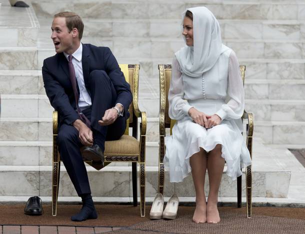Prince William and his wife Kate, the Duke and Duchess of Cambridge take their shoes off before entering a mosque in Kuala Lumpur, Malaysia, Friday, Sept. 14, 2012.