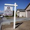 Photo: A for sale sign stands outside a bank-owned home i Photo: A for sale sign stands outside a bank-owned home i