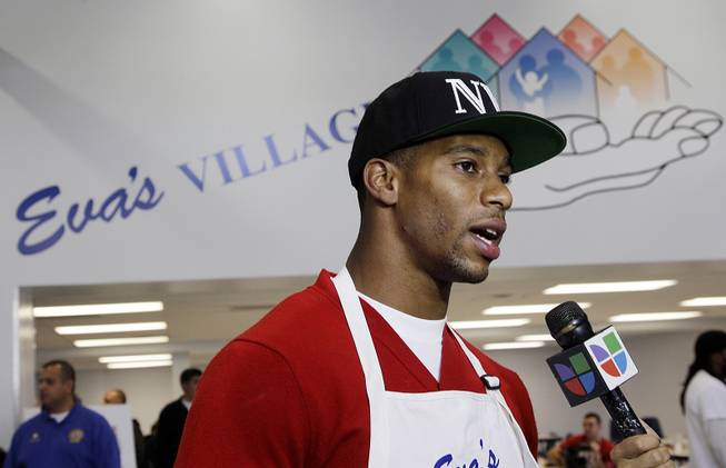New York Giants football standout Victor Cruz answers a question as he helps to prepare dinner for the needy at Eva's Village in Paterson, N.J., Nov. 20, 2012. 