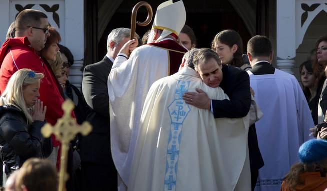 A mourner of teacher Anne Marie Murphy, who was killed at the Sandy Hook Elementary School shootings in Newtown, Conn., hugs an officiate at St. Mary Of The Assumption Church after a funeral service in Katonah, N.Y. Thursday, Dec. 20, 2012. Murphy was killed Adam Lanza, walked into Sandy Hook Elementary School in Newtown, Conn., Dec. 14, and opened fire, killing 26, including 20 children, before killing himself.