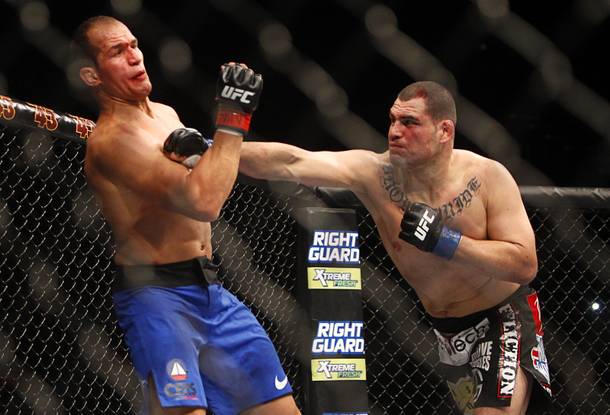 Cain Velasquez, right, connects with a punch that staggers heavyweight champion Junior Dos Santos during the first round of their heavyweight title bout UFC155 at the MGM Grand Garden Arena Saturday, Dec. 29, 2012. Velasquez took back the title by unanimous decision.